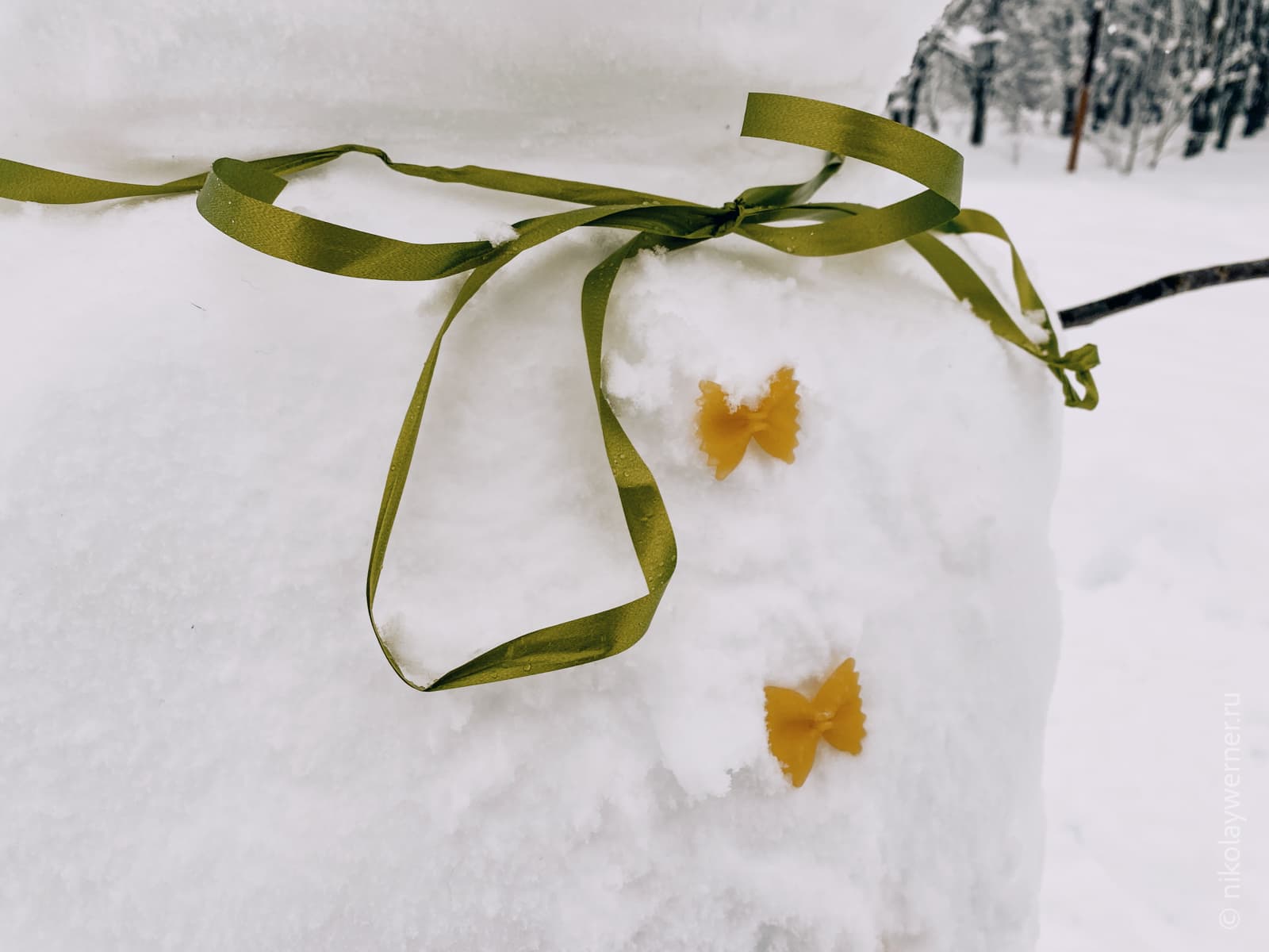 Фрагмент снеговика. Шея подвязана зеленой ленточкой, на груди красуются пуговицы их макаронин-бантиков