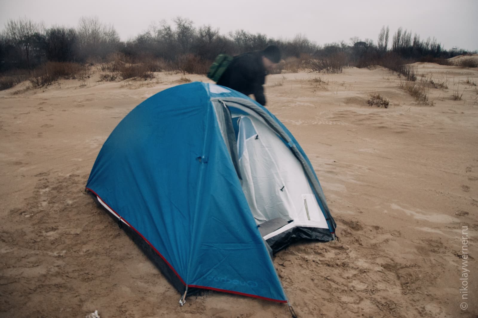 Синяя палатка вблизи. Стоит на песке.